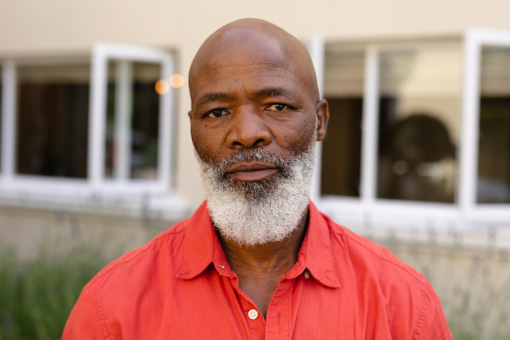 Close-up portrait of bald bearded african american senior man standing outdoors